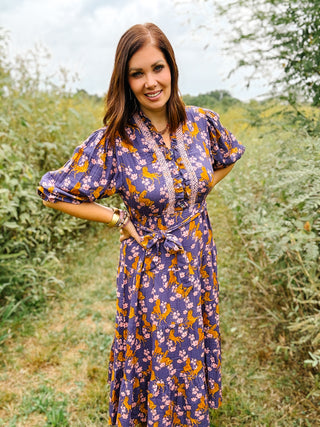 ivy jane dress with golden horses and pink flower print on a deep purple plum background tiered midi dress with tie waist and ruffle neckline