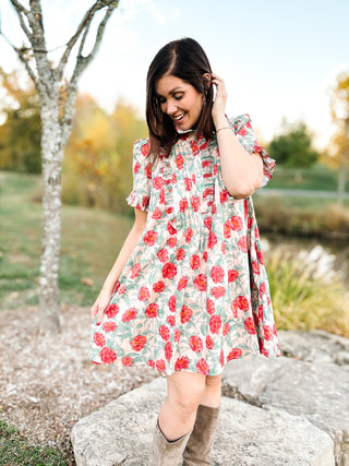 woman in a fall setting wearing a blush floral mini dress