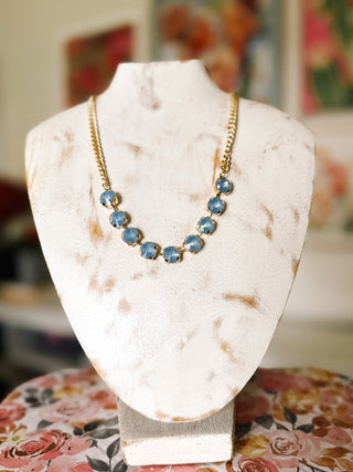 Shop this smoky blue statement necklace with round faceted stones and a gold-tone chain. A beautiful finishing touch for dresses, blouses and everyday outfits.