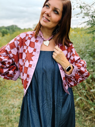 Bold rust red star and check appliqué quilted jacket on a lilac-lavender base, with cropped, relaxed fit with elastic hem and balloon sleeves