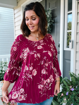 Ginger burgundy floral blouse with pintuck detailing, flowy fit and three-quarter sleeves styled with jeans for fall.