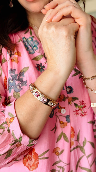 Person wearing a floral dress with visible jewelry