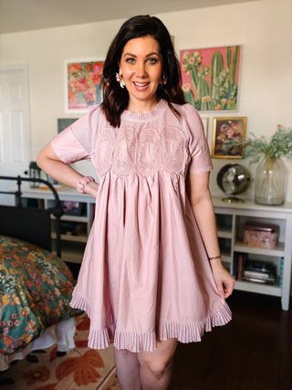 Blush mauve pink babydoll dress with lace yoke detail, short sleeves, and pleated ruffle hem
