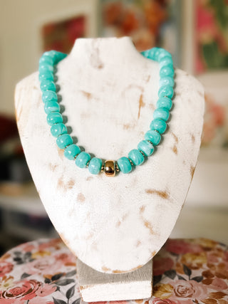 Turquoise chunky beaded statement necklace with glossy aqua and white marbled beads, small gold-tone spacers, and a polished gold center bead.